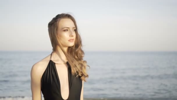 Gyönyörű lány tengerparton naplementekor portréja — Stock videók