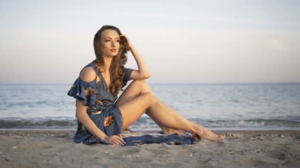 Jovem menina alegre atraente sentado na praia — Vídeo de Stock