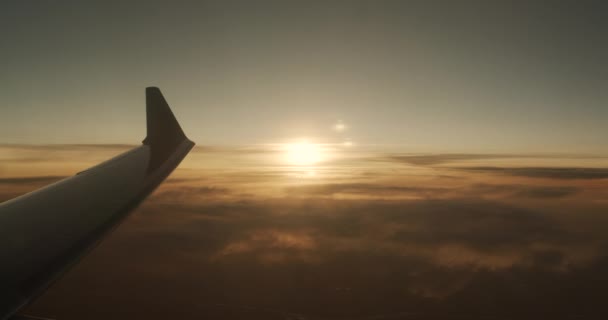 Lot samolotem nad chmurami. Czerwono-pomarańczowy zachód słońca. — Wideo stockowe
