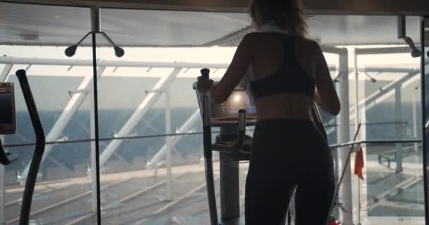 Sportmädchen auf Orbitrek in der Turnhalle. Hartes Cardio-Training. — Stockvideo