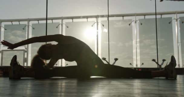 Joven, bonita mujer haciendo el calentamiento antes de entrenar en el gimnasio . — Vídeo de stock