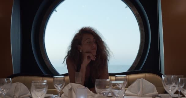 Fille seule à une table dans un restaurant manque et boit du champagne . — Video