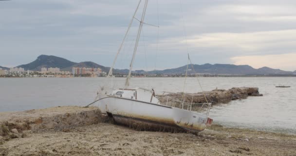 Поврежденная яхта после аварии. Яхта бросила на камни . — стоковое видео