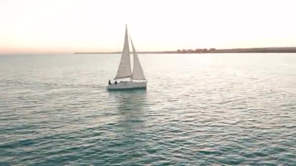Αεροφωτογραφία. Ιστιοπλοϊκό σκάφος στη θάλασσα στο ηλιοβασίλεμα. — Αρχείο Βίντεο