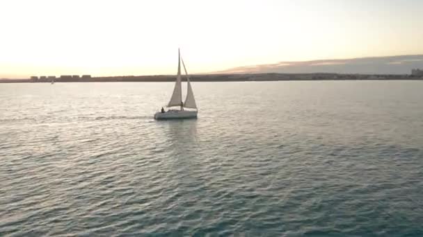 Vue aérienne. Bateau à voile sur la mer au coucher du soleil . — Video