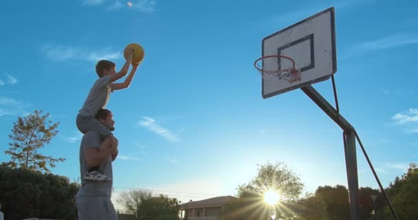 Far med son njuta av en dag i parken och spela basket. — Stockvideo