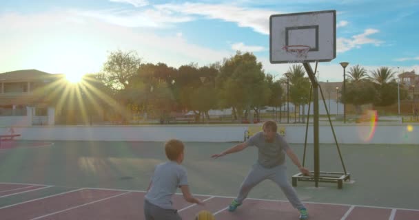 Otec se synem si užívají den v parku a hrají basketbal. — Stock video