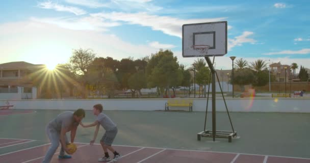 Far med son njuta av en dag i parken och spela basket. — Stockvideo