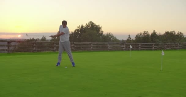 Człowiek golfista w zachodzie słońca korzystających wakacje na luksusowym kurorcie. — Wideo stockowe