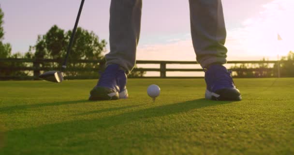 Golfçü parlak günbatımında golf sahasında golf topuna vuruyor. Golf sporu konsepti. Yakın çekim.. — Stok video