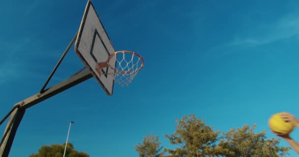 Hombre jugador de baloncesto slam dunking en una cancha de baloncesto al aire libre . — Vídeos de Stock