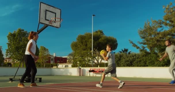 Сын играет в баскетбол с отцом и матерью . — стоковое видео
