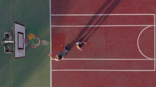 Flygfoto. far och son spelar basket på planen utomhus. — Stockvideo