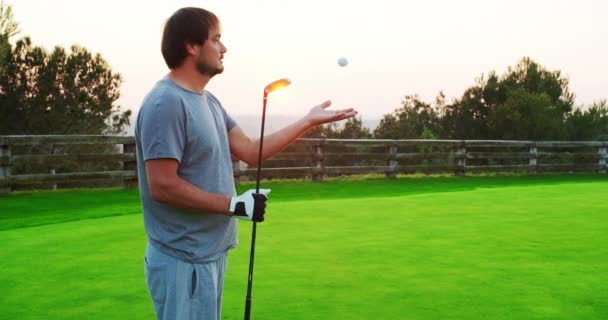 Καυκάσιος παίκτης του γκολφ που κρατάει μπαστούνι και ρίχνει μπάλα του γκολφ. — Αρχείο Βίντεο