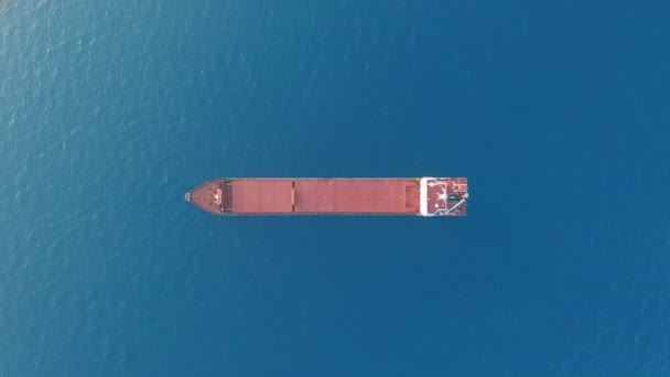 Vue aérienne. Navire cargo à pont rouge naviguant en haute mer .