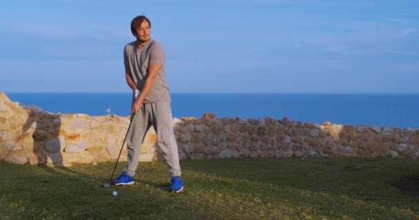 Man golfer in zonsondergang genieten van vakantie op luxe resort. — Stockvideo