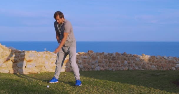 Man golfer στο ηλιοβασίλεμα απολαμβάνοντας διακοπές σε πολυτελές θέρετρο. — Αρχείο Βίντεο