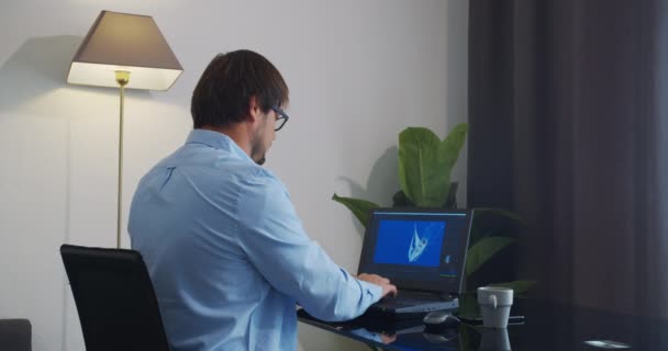 Evden internet üzerinden çalışan bir adam dizüstü bilgisayar kullanıyor. — Stok video