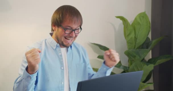 Joven profesional urbano exitoso hombre de negocios recibiendo buenas noticias en los negocios. El éxito y el logro - el empresario feliz que celebra mirar el portátil . — Vídeo de stock