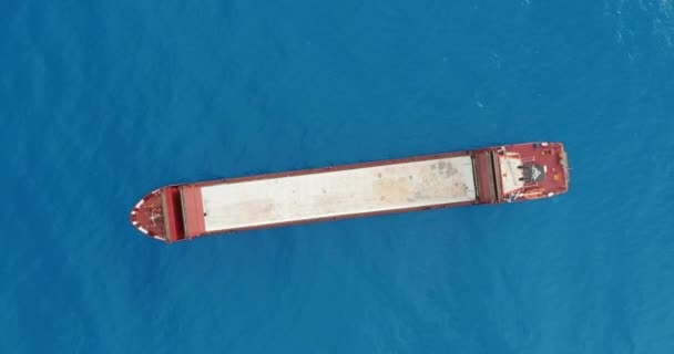 Aerial view. Red deck cargo ship sailing on open sea. — Stock Video