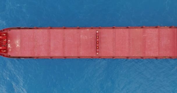 Aerial view. Red deck cargo ship sailing on open sea. — Stock Video