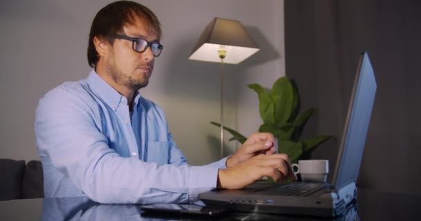 Businessman in eyeglasses with laptop computer drinking coffee or tea at office. Business, people and technology concept. — Stock Video
