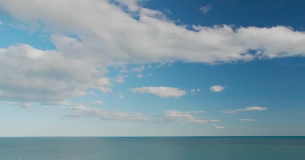 Θέα στη θάλασσα την ωραία μέρα του καλοκαιριού, καθαρά μπλε νερά και απαλά κύματα, μπλε ουρανός με σύννεφα, γραμμή ορίζοντα. Από 1 Ιανουαρίου μέχρι 31. — Αρχείο Βίντεο