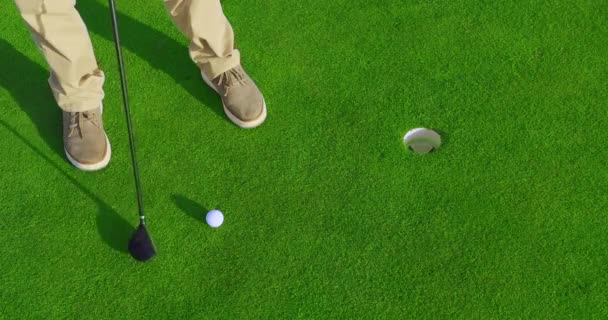 Dospělý muž odpaluje golfový míček při západu slunce. Closeup. — Stock video