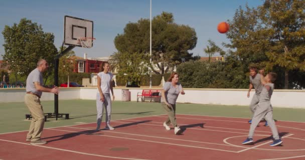 Aile basketbolcuları oyun alanında antrenman yapıyor. Rakip hücum, top sahibi, liderlik pozisyonu değişikliği.. — Stok video