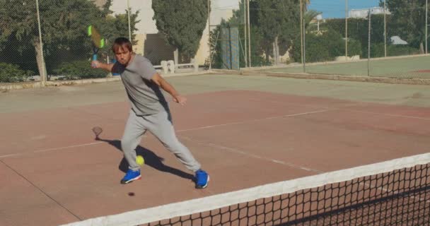 Een professionele tennisspeler Hitting op bal met tennisracket op Clay Court. — Stockvideo