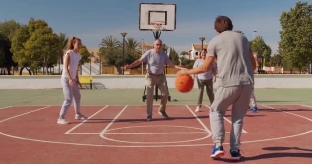 Wielopokoleniowa rodzina gra w koszykówkę na boisku. — Wideo stockowe