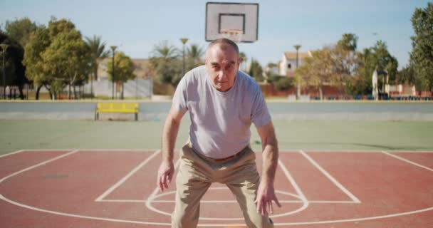 Velho homem jogar na quadra de basquete . — Vídeo de Stock