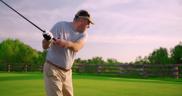 Yakışıklı yaşlı golfçü golf sopasını sallıyor, cennette golf oynuyor.. — Stok video