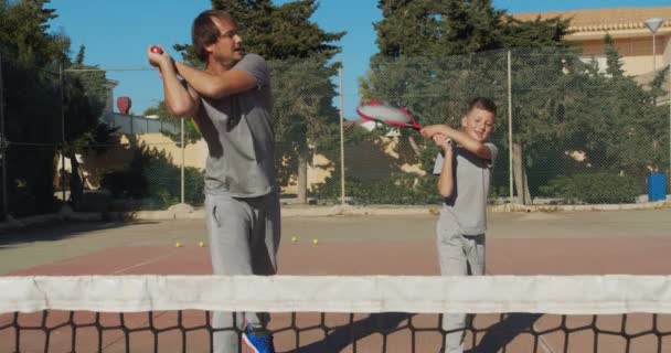 Pai e filho a jogar ténis na quadra. Treinamento de tênis . — Vídeo de Stock