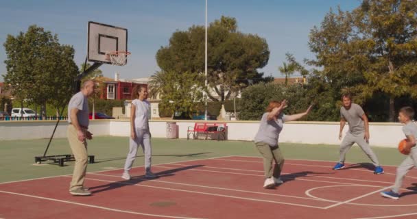 Famiglia multigenerazione che gioca a basket sul campo all'aperto . — Video Stock