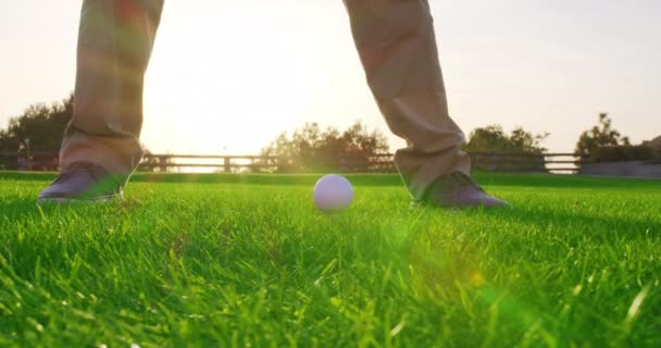 De mens golft en gooit de bal in het gat. Close-up. — Stockvideo