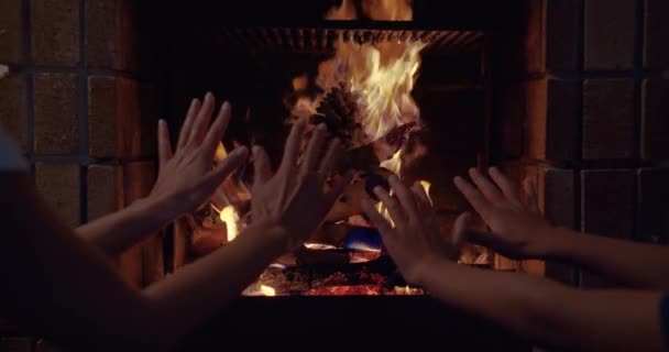 Couple hands warms his hands by the fire burning fireplace. Closeup of hands. — Stock Video