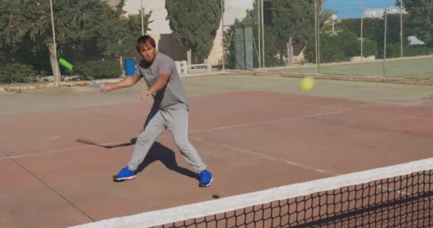 Athlète masculin jouant au tennis sur un terrain dur extérieur. Homme heureux dans la célébration du succès et gagner . — Video