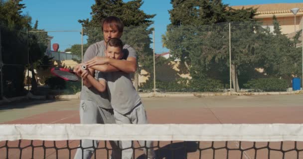 Vader en zoon tennissen op het veld. Tennistraining. — Stockvideo