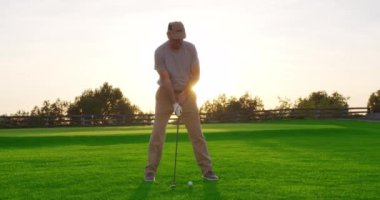 Yakışıklı yaşlı golfçü golf sopasını sallıyor, cennette golf oynuyor..