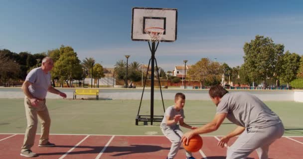 Flergenerationens familj spelar basket på friluftsplan. — Stockvideo