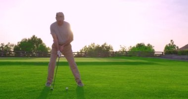 Yakışıklı yaşlı golfçü golf sopasını sallıyor, cennette golf oynuyor..
