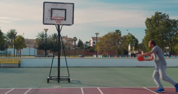 Basketbalspeler training. Spelen op Basketbalveld. Basketbalspeler stuiteren met de bal. — Stockvideo