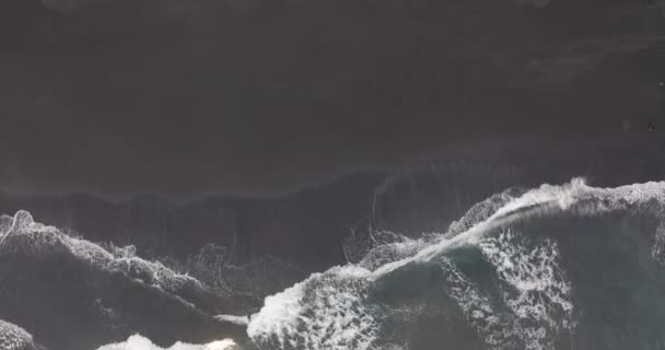 Hava görüntüsü. Siyah kum plajı. Güzel okyanus dalgaları kıyı şeridine çarpıyor. Tenerife 'nin doğal volkanik plajı, Kanarya adaları. — Stok video