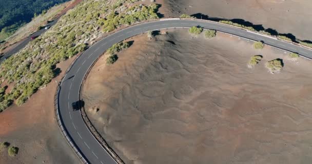 空中射撃だ。見下ろして。車は新しい理想的に平らなアスファルトの道路行く。新鮮な白い道路標識。赤い石の砂漠の風景の背景に。スペイン,カナリア諸島,テネリフェ島. — ストック動画