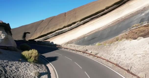 Luchtfoto 's. Ik kijk naar beneden. Auto gaan nieuwe ideaal vlakke asfaltweg. Verse witte wegmarkeringen. Tegen de achtergrond van de rode steen woestijn landschap. Spanje, Canarische Eilanden, Tenerife. — Stockvideo