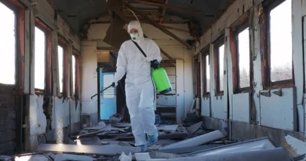 Virologist in protective costume and respirator disinfects surfaces. — Stock Video