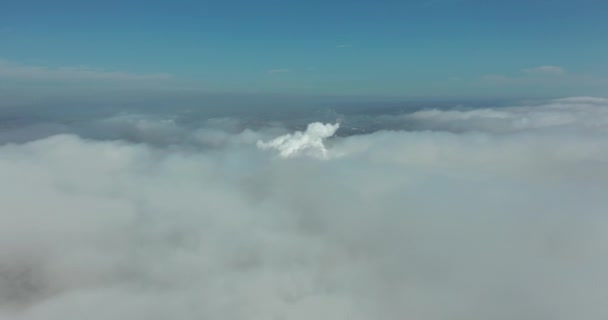Hava görüntüsü. Hareket eden beyaz bulutların arasından manzaralı hava manzarası. Sis.