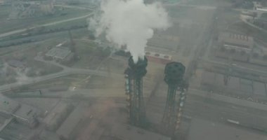 Duman emisyonlu yüksek boruların destansı havası. Bitki boruları atmosferi kirletir. Endüstriyel fabrika kirliliği, baca bacası egzoz gazı. Endüstri bölgesi, yoğun duman bulutları. İklim değişikliği, ekoloji.