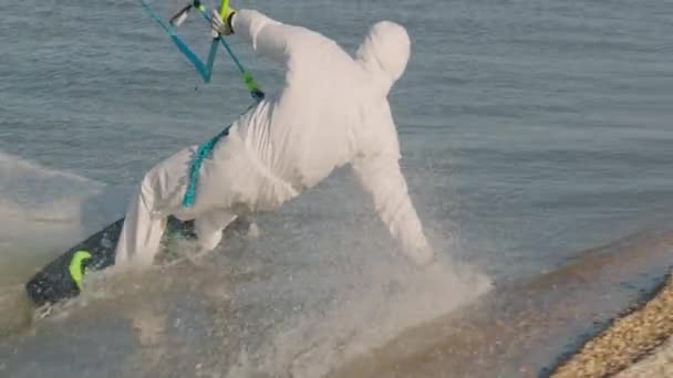 Pria yang mengenakan peralatan pelindung medis berselancar di lautan, olahraga musim panas yang ekstrim dalam gerakan lambat. Wabah wabah virus.. — Stok Video